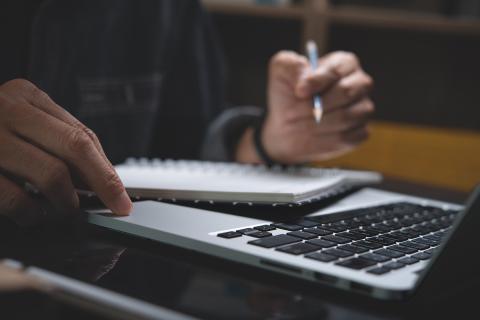 A photo of someone writing in a document