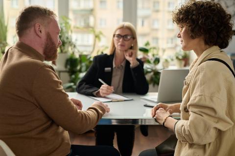 Group of three people sat around a desk